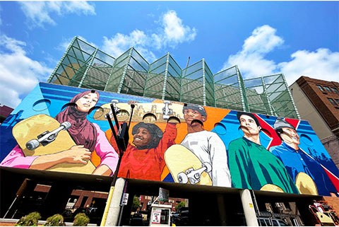 colorful mural of diverse children holding skateboards